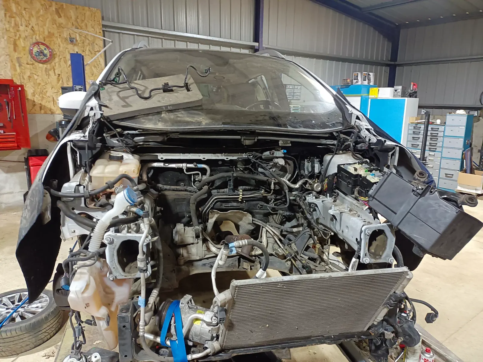 Voiture en cours de réparation mécanique, face avant déposée, moteur et radiateur accessibles