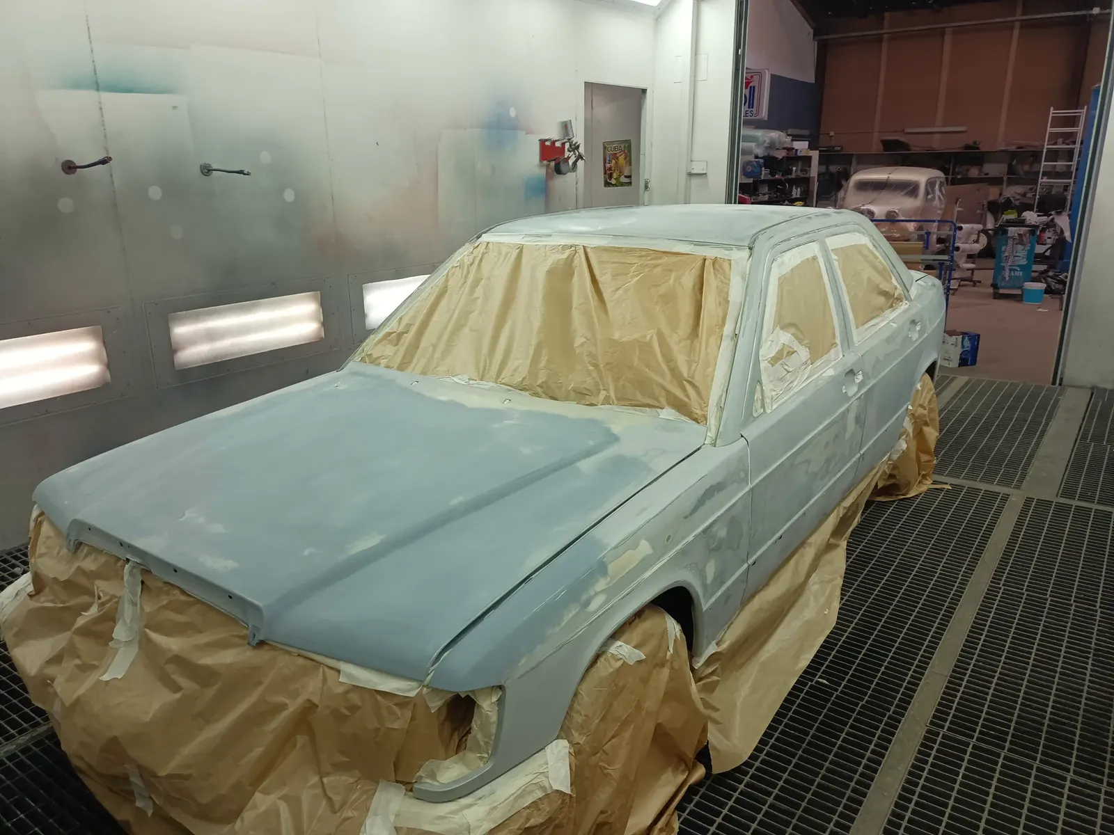 Carrosserie préparée et masquée en cabine, prête pour la mise en peinture