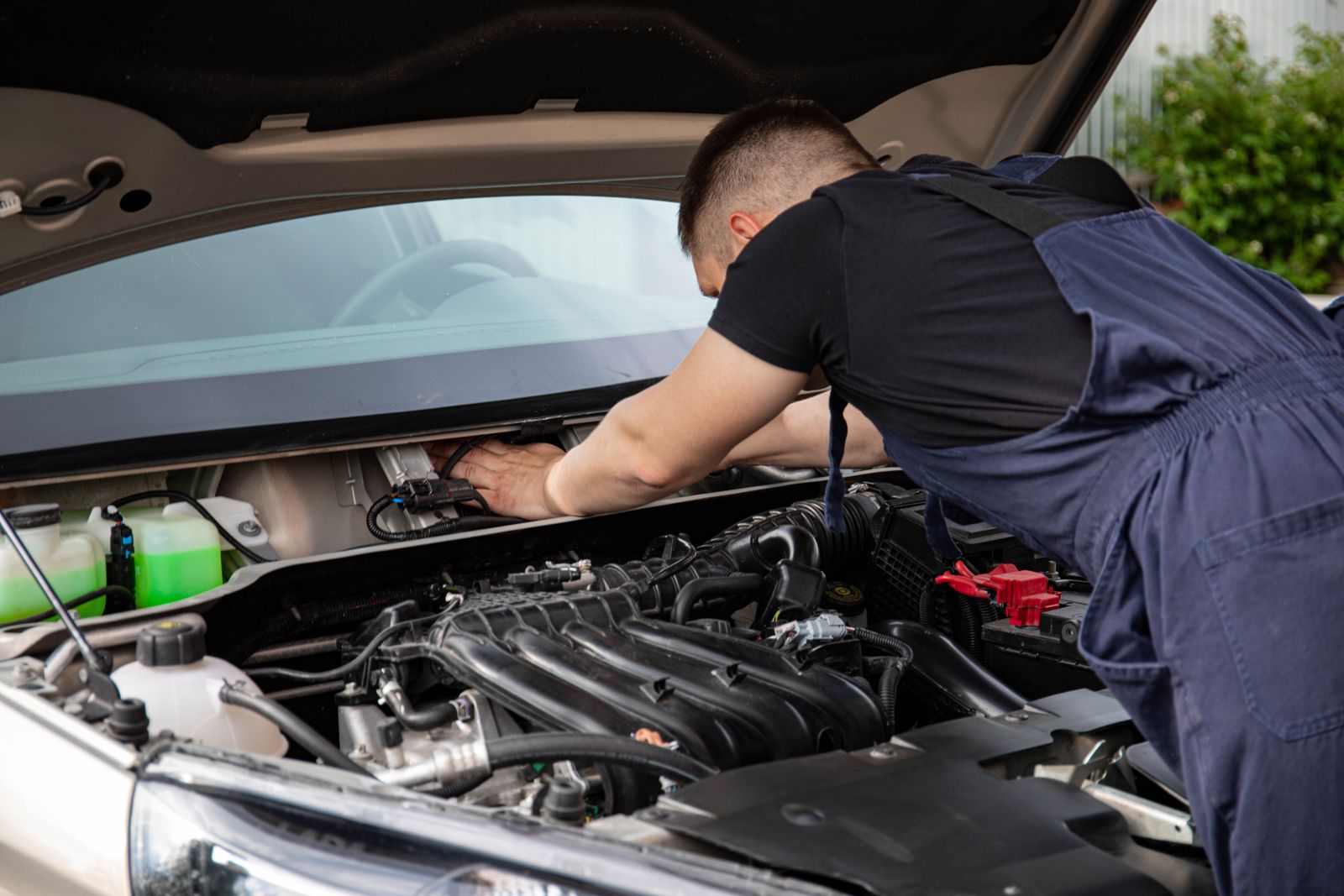 Mains d'un mécanicien travaillant sur les composants du moteur d'une voiture